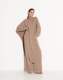 Woman wearing Valencia beige wool poncho and matching wide-leg pants set by Aina Gasse