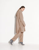 Woman styling a beige oversized knit cardigan with coordinated pants for an elegant everyday look