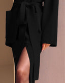 Black knit maxi skirt featuring an elegant slit detail.