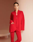 Woman wearing a red outfit against a beige background