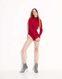Woman wearing a red sweater and gray boots on a white background