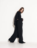 Side view of black Italian wool poncho with tailored pants from the Valencia collection