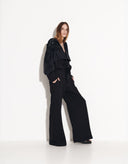 Side view of women’s black wide-leg cotton jumpsuit with a relaxed silhouette